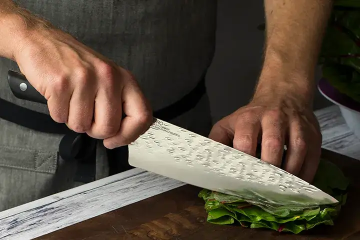 Chef's knife correctly slicing chard